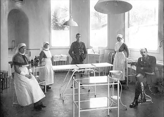 Razilly - Cirurgia Plástica e Neurologia - Figura 1. Sir Harold Gillies (à direita, sentado) na sala cirúrgica, Queen's Hospital, Sidcup (Cedida por Dr. Andrew Bamji, Gillies Archivist, BAPRAS).